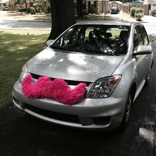 A Lyft car with its trademark pink mustache.