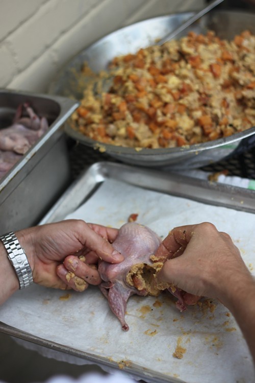 Chef Jeff McInnis of Yardbird stuffs quail with fois gras, grilled peaches, and cornbread.