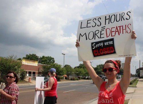 Dani Rutherford protests the proposed MAS hour cut on Sunday.