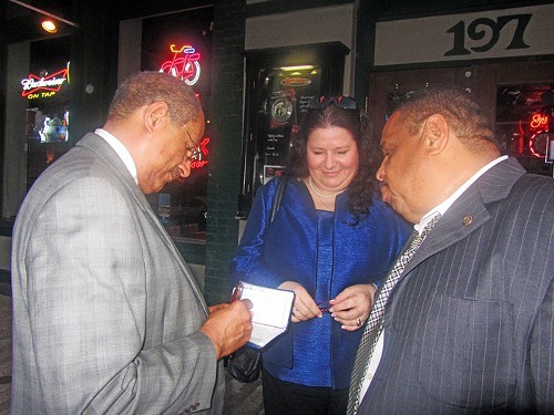 Ex-candidate (and plaintiff) Shep Wilbun makes out check for election appeal as fellow plaintiffs Regina Newman and Randy Wade watch.