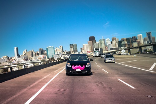 Lyft cars have pink moustaches.