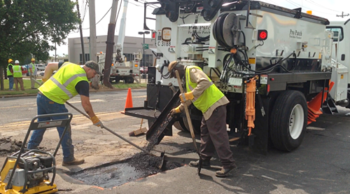 Memphis Public Works road workers show off the citys new pothole-fixing truck.