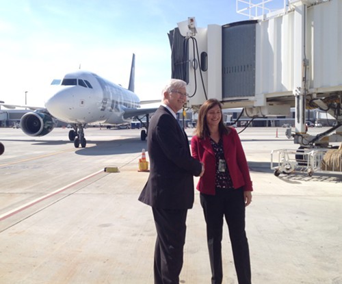 Scott Brockman and Andrea Blankenship in front of the first arriving Frontier flight