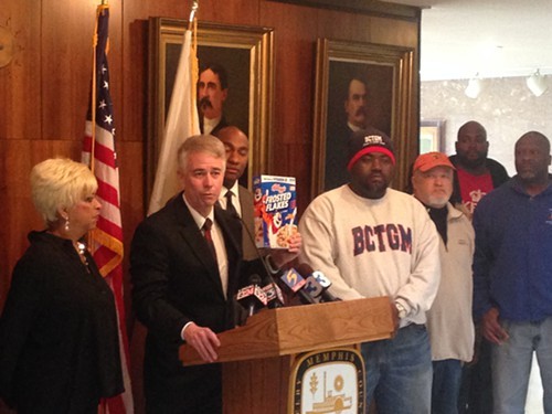 Shelby County Commissioner Steve Mulroy holds up a box of Kelloggs Frosted Flakes during a Monday news conference.